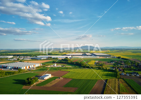 Aerial view of logistics center surrounded by farmland and countryside homes 127355391
