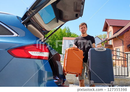 Man with suitcases near car, preparing for moving 127355398