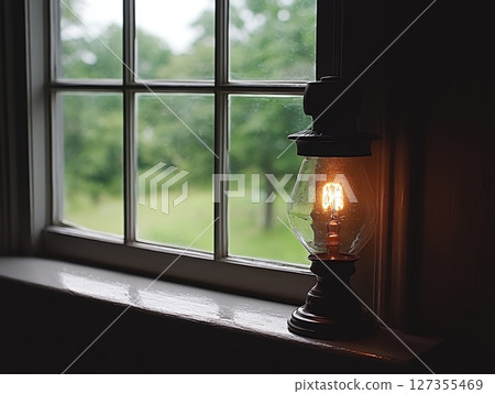 Vintage Glass Lamp Illuminates Window Rustic Home Decor Still Life Warm Light old cozy bulb room 127355469