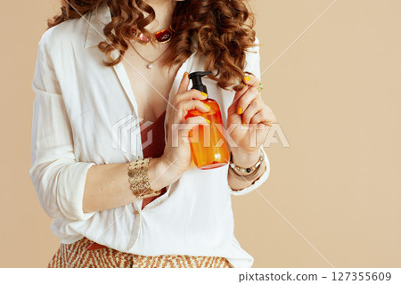 Stylish woman in blouse and shorts isolated on beige 127355609