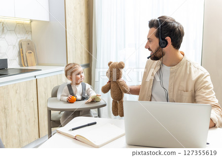 Young man having a call on internet while doing babysitting Young man having a call on internet while doing babysitting 127355619