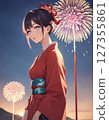 A woman wearing a yukata participating in a fireworks display 127355861