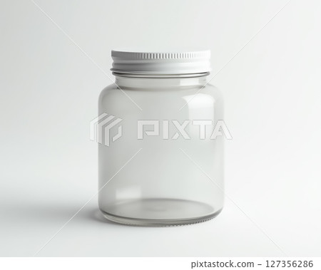 Clear glass jar with white lid placed on a neutral background for storage and organization Clear glass jar with white lid placed on a neutral background for storage and organization 127356286