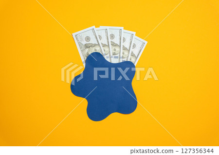 Dollar bills are hidden behind a dark spot. The concept of money of uncertain origin. Money laundering, tax evasion, or unexplained income in financial investigations. 127356344