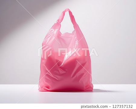 Bright pink plastic bag filled with various items sits on a clean surface in a well-lit space during the day Bright pink plastic bag filled with various items sits on a clean surface in a well-lit space during the day 127357132