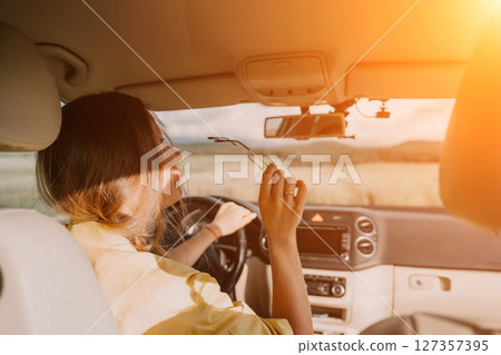 Happy woman talking on the phone while sitting in the car on nature Relaxed video call, professional conversation, female executive in automobile. business woman talking on video call on phone. 127357395
