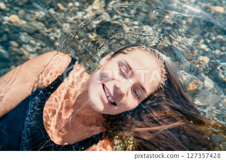 Woman Floating in Crystal Clear Water Woman Floating in Crystal Clear Water 127357428
