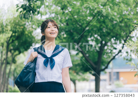 A high school girl in summer clothes commuting to school 127358043