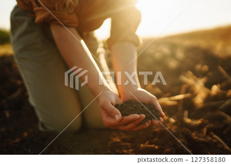 Woman farmer's hand touch soil, check its health before growing plants, seeds. Agriculture concept 127358180