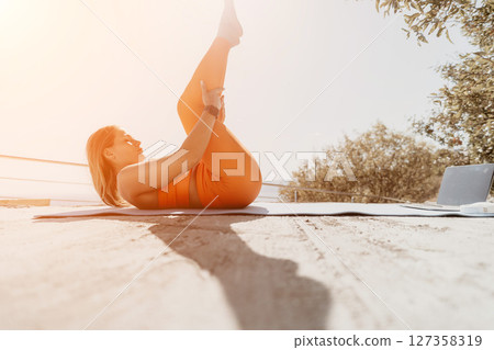 Young Woman Practicing Yoga on a Sandy Beach 127358319