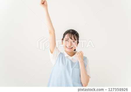 Young woman in apron, fist pump 127358926
