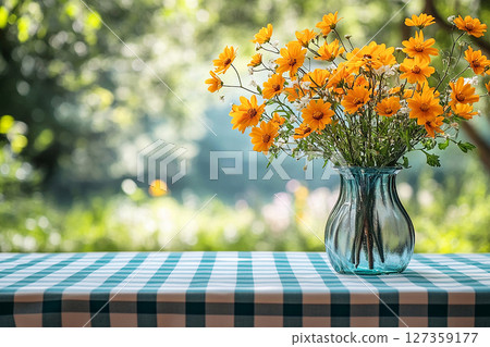 Picnic table with checkered tablecloth and a vase with flowers on a summer background. Retro-style. Mockup. Copy space. 127359177