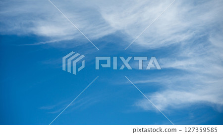 Soft white cirrus clouds against the blue sky 127359585