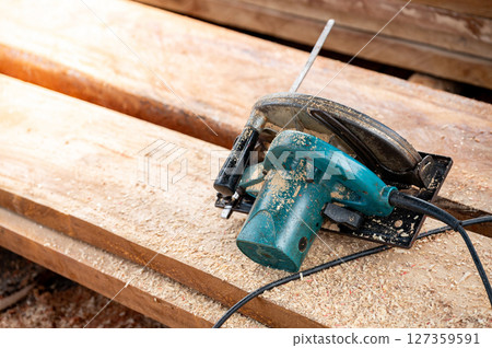 Electric circular saw on timber stack Electric circular saw on timber stack 127359591