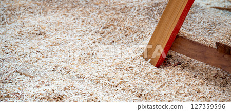 Sawdust heap under workbench leg in the wood workshop 127359596