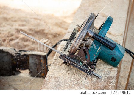 Electric circular saw on timber stack. Work tool for carpentry 127359612