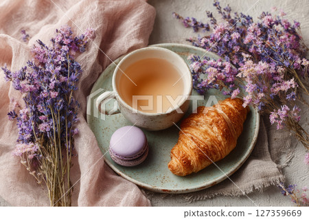 Croissant and tea on pastel plate with lavender bouquet 127359669