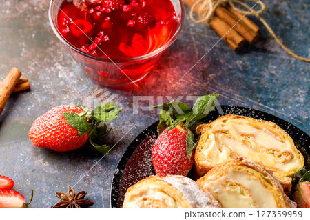 Sliced rolls with custard. The dessert is decorated with fresh strawberries. 127359959
