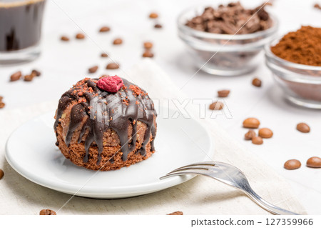 Round chocolate cakes. Decorated with candied raspberries. Light background. Round chocolate cakes. Decorated with candied raspberries. Light background. 127359966