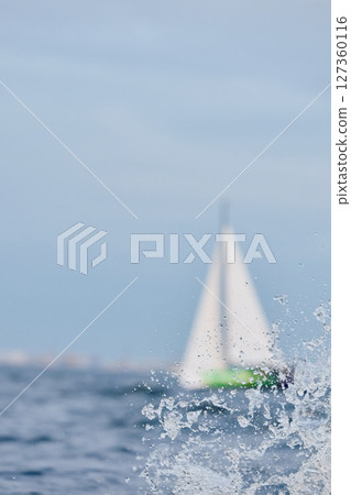 Sailing regatta in the Gulf of Finland at sunset, sailing yacht competing in a race, splashing water from under the boat, teamwork, board the boat 127360116