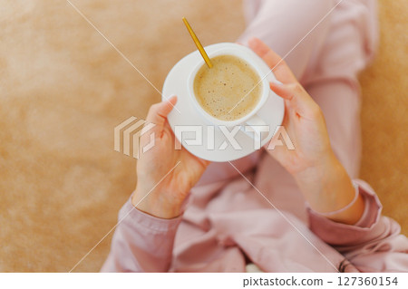 faceless woman with a cup of coffee on the beige Interior pile carpet. 127360154