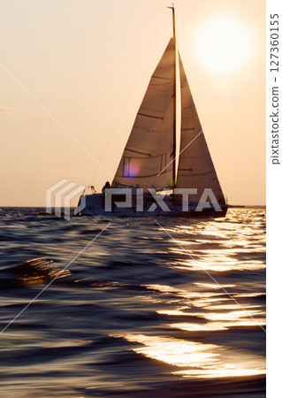 Sailing regatta in the Gulf of Finland at sunset, sailing yacht competing in a race, splashing water from under the boat, teamwork, board the boat 127360155