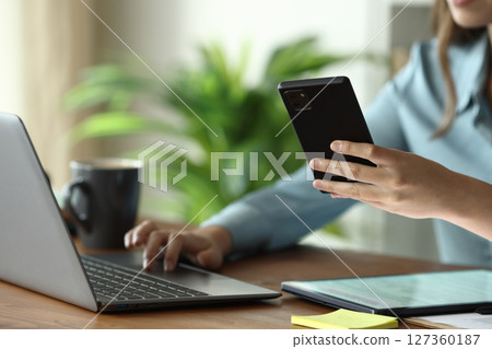 Businesswoman hands using multiple devices on a wooden table Businesswoman hands using multiple devices on a wooden table 127360187