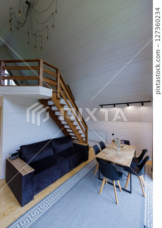 Stylish Open Living Space with Modern D cor Featuring a Cozy Sofa and Elegant Dining Table Surrounded by Chairs in a Contemporary Setting Stylish Open Living Space with Modern D cor Featuring a Cozy Sofa and Elegant Dining Table Surrounded by Chairs in a Contemporary Setting 127360234