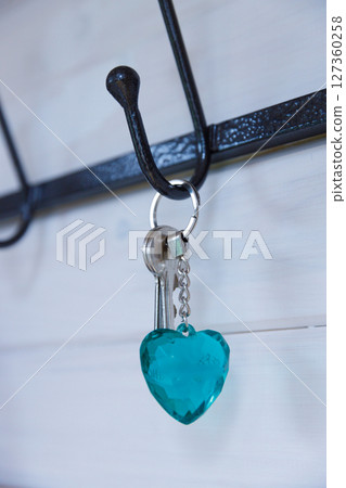 A Charming Keychain with a Heart-Shaped Turquoise Pendant Hanging on a Metal Hook, Perfect for Organizing and Adding a Pop of Color to Any Entrance or Room Decor A Charming Keychain with a Heart-Shaped Turquoise Pendant Hanging on a Metal Hook, Perfect for Organizing and Adding a Pop of Color to Any Entrance or Room Decor 127360258