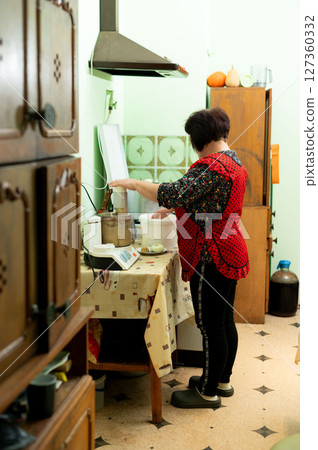 On a leisurely afternoon, I'm in a cozy kitchen surrounded by warmth and love, joyfully preparing fresh ingredients for a delicious meal 127360332