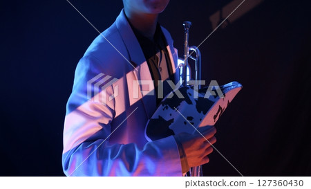 A man holding a trumpet and a ten-gallon hat 127360430