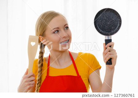 Woman holding cooking pan and spatula 127360761