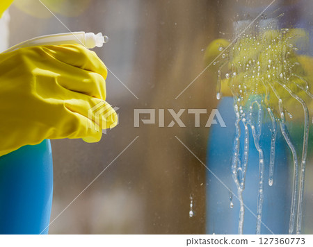 Person spraying window cleaning detergent Person spraying window cleaning detergent 127360773