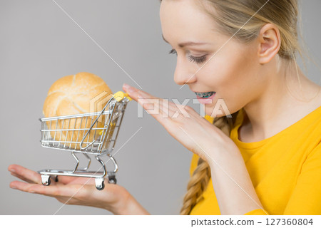 Woman holding shopping cart with bread 127360804