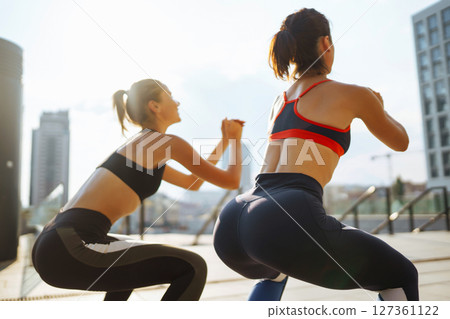 Two Young woman exercising and stretching outdoors in the morning. Sport, Active life. Two Young woman exercising and stretching outdoors in the morning. Sport, Active life. 127361122