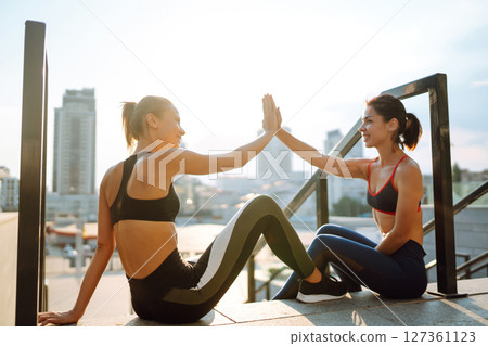 Two Young woman exercising and stretching outdoors in the morning. Sport, Active life. Two Young woman exercising and stretching outdoors in the morning. Sport, Active life. 127361123