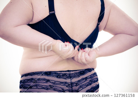 Woman back view putting on her bra lingerie. Woman back view putting on her bra lingerie. 127361158