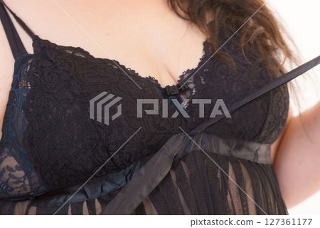 Woman in black lingerie showing her breast chest. Woman in black lingerie showing her breast chest. 127361177