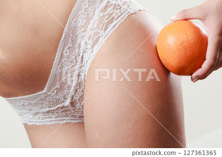 Girl holding orange next to bottom 127361365