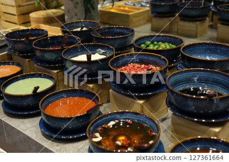 Sauces condiments utensils various spices and additives for oriental asian soup cabbage lime meat in blue plates with spoons in buffet Sauces condiments utensils various spices and additives for oriental asian soup cabbage lime meat in blue plates with spoons in buffet 127361664