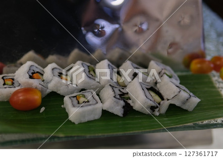 Set of sushi rolls dragon on a black matte plate. Japanese traditional sushi dish with avocado, eel and soy sauce. A beautiful dish for an Asian restaurant menu. 127361717