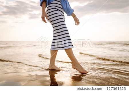 Woman leg close up walking on sand relaxing in beach at sunset. Sexy lean and tanned legs. Woman leg close up walking on sand relaxing in beach at sunset. Sexy lean and tanned legs. 127361823