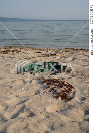 Plastic waste washed up on a sandy beach 127361972