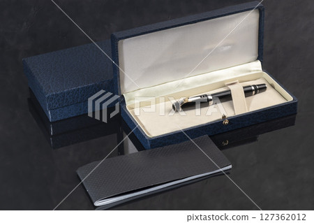 Branded pen in a box. Gift set. Selective focus. Office interior. 127362012
