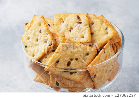 Delicious healthy cookies crackers with flax seeds and sesame seeds on a plate. Background of a healthy snack food, close up. 127362257