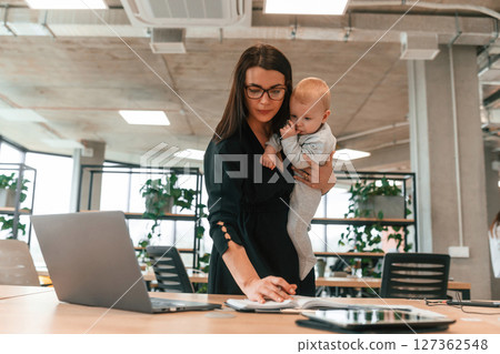 Young mother with her little baby son is in the office Young mother with her little baby son is in the office 127362548