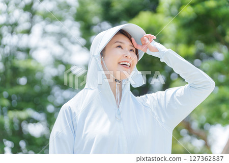 一名女子穿著防曬衣來保護自己免受紫外線的傷害 127362887