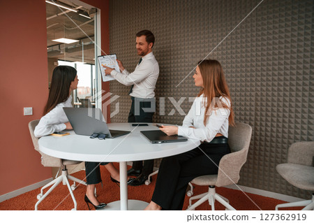 Manager is showing the plan project. Three business people are working in the office together 127362919