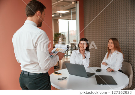 Three business people are working in the office together Three business people are working in the office together 127362923