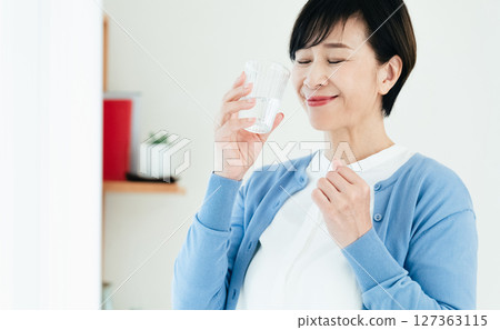 Middle woman drinking water 127363115